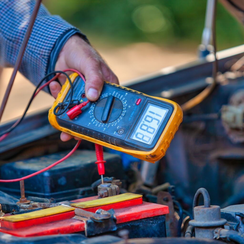 person checking car battery voltage